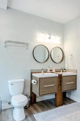 a bathroom with a toilet and a sink with two mirrors at Ski in Ski Out with Huge Game Room and Hot Tub in Fernie
