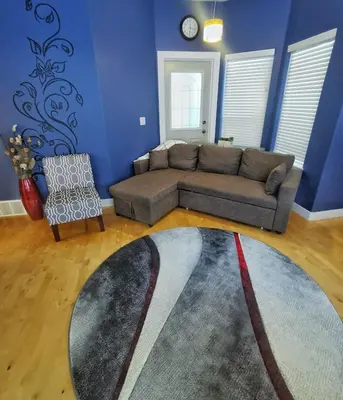 a living room with a couch and a rug at LuxQuarters Kitimat River Suite in Kitimat