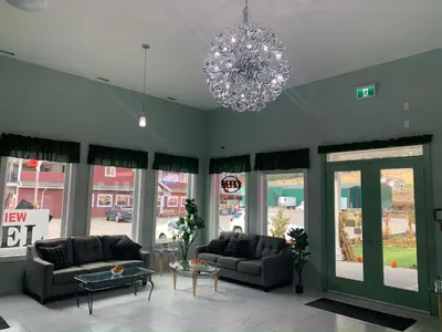 a living room with two couches and a chandelier at Orchard View Motel in Keremeos