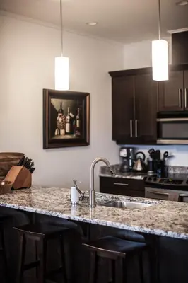 a kitchen with a sink and a counter with stools at Alpenglow Penthouse by Revelstoke Vacations in Revelstoke