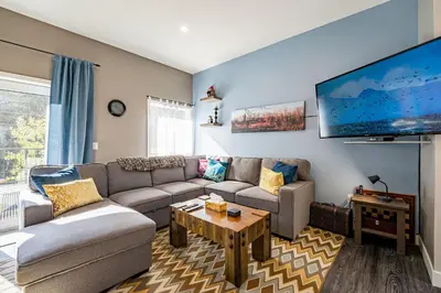 a living room with a couch and a tv at Pillow Top Condo by Revelstoke Vacations in Revelstoke