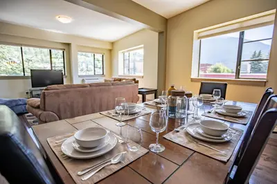 a dining room with a table with plates and wine glasses at Selkirk Snug by Revelstoke Vacations in Revelstoke