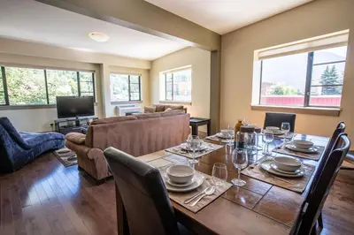 a dining room with a table and a couch at Selkirk Snug by Revelstoke Vacations in Revelstoke