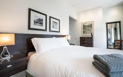 a bedroom with a white bed and two pictures on the wall at In the Heart of it All by Revelstoke Vacations in Revelstoke