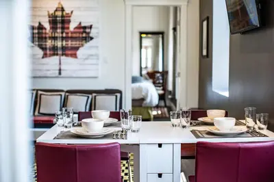 a table with chairs and plates and glasses on it at In the Heart of it All by Revelstoke Vacations in Revelstoke