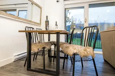 a dining room table with two chairs with fur cushions on them at Revelstoke Retreat by Revelstoke Vacations in Revelstoke