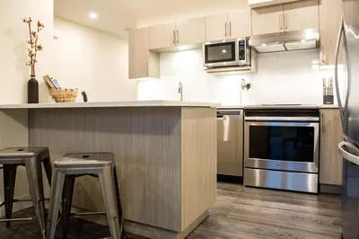 a kitchen with stainless steel appliances and wooden cabinets at Revelstoke Retreat by Revelstoke Vacations in Revelstoke