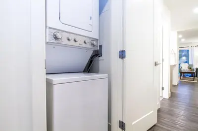 a white kitchen with a washer and dryer at Revelstoke Retreat by Revelstoke Vacations in Revelstoke