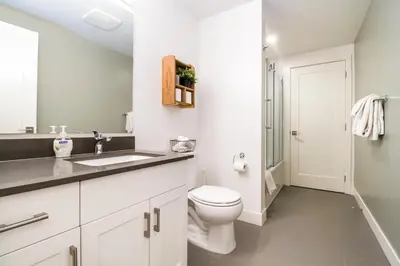 a white bathroom with a toilet and a sink at Revelstoke Retreat by Revelstoke Vacations in Revelstoke