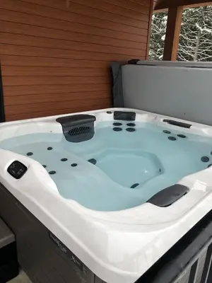 a large bath tub sitting in a room at Revelstoke Retreat by Revelstoke Vacations in Revelstoke