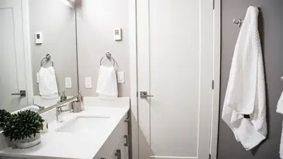 a white bathroom with two sinks and a shower at The Revy Den by Revelstoke Vacations in Revelstoke