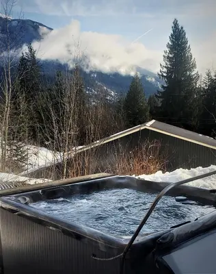 a hot tub with snow on top of it at Stoke Cabin by Revelstoke Vacations in Revelstoke