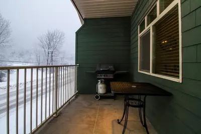 a green house with a table and a grill on a balcony at Give Something Back Retreat by Revelstoke Vacations in Revelstoke