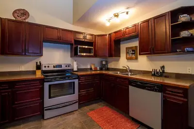 a kitchen with wooden cabinets and a stove top oven at Give Something Back Retreat by Revelstoke Vacations in Revelstoke