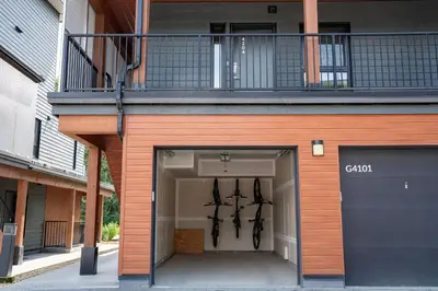 a building with a garage with a balcony on top at The Mac Shack by Revelstoke Vacations in Revelstoke