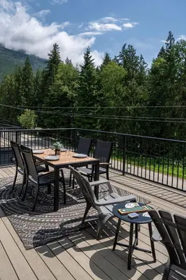 a patio with tables and chairs on a deck at The Mac Shack by Revelstoke Vacations in Revelstoke