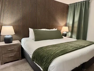 a bedroom with a large bed and two lamps at Granite Ridge Condo by Revelstoke Vacations in Revelstoke