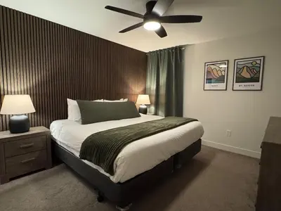 a bedroom with a bed with a ceiling fan at Granite Ridge Condo by Revelstoke Vacations in Revelstoke