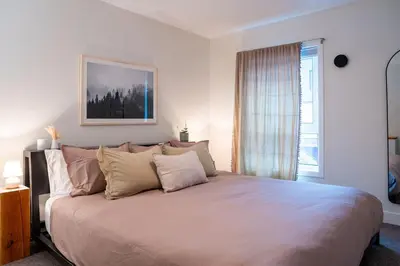 a large bed in a bedroom with a window at Powder Village Retreat by Revelstoke Vacations in Revelstoke
