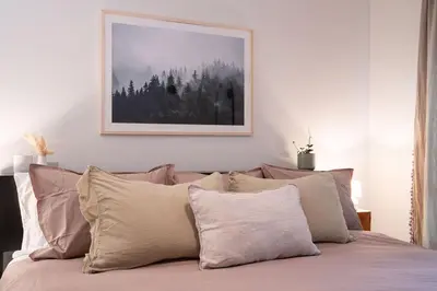 a bed with some pillows and a picture on the wall at Powder Village Retreat by Revelstoke Vacations in Revelstoke