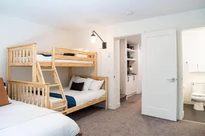 a bedroom with two bunk beds and a bathroom at Revelation Retreat by Revelstoke Vacations in Revelstoke