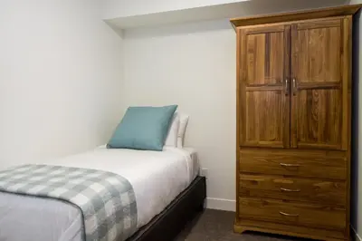 a bedroom with a bed and a wooden dresser at Magog Condo by Revelstoke Vacations in Revelstoke