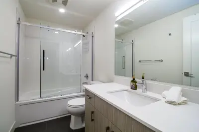 a bathroom with a shower and a toilet and a sink at Magog Condo by Revelstoke Vacations in Revelstoke