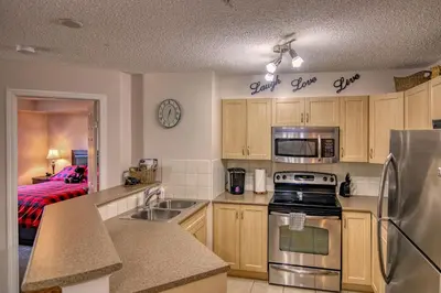 a kitchen with a sink and a stove top oven at Mountain getaway condo - 5 min walk to the beach! in Invermere