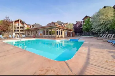 a large swimming pool in front of a house at Mountain getaway condo - 5 min walk to the beach! in Invermere