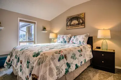 a bedroom with a bed and a window at Mountain getaway condo - 5 min walk to the beach! in Invermere