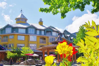 a large yellow building with a tower on top at Bear Lodge One Bedroom by MVA in Whistler