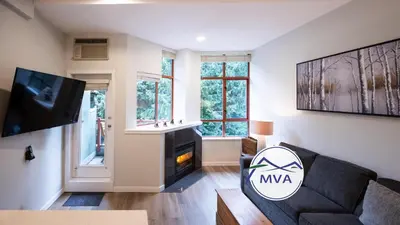 a living room with a couch and a fireplace at Alpenglow Lodge Snooze Studio with Den by MVA in Whistler