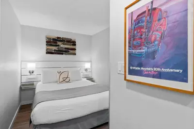 a bedroom with a bed and a painting on the wall at Alpenglow Lodge Snooze Studio with Den by MVA in Whistler