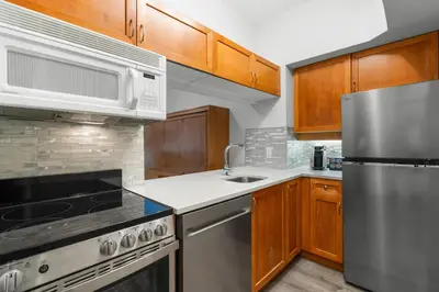 a kitchen with wooden cabinets and stainless steel appliances at Alpenglow Lodge Studio with Pool Views by MVA in Whistler