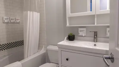 a white bathroom with a sink and a toilet at Alpenglow Lodge Studio with Pool Views by MVA in Whistler