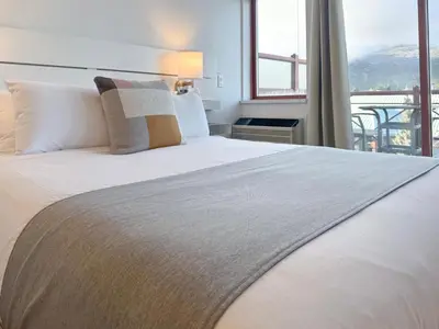 a bedroom with a large bed with a large window at Alpenglow Lodge Rainbow Look Out Studio by MVA in Whistler