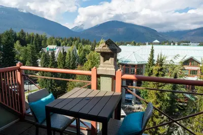 a balcony with a table and chairs and mountains at Alpenglow Lodge Junior Penthouse by MVA in Whistler