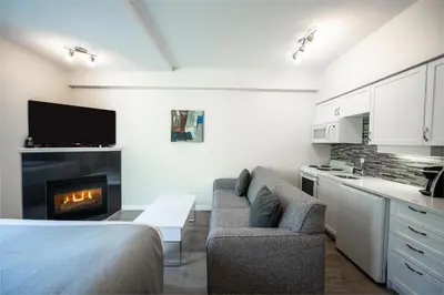 a living room with a couch and a fireplace at Alpenglow Lodge Sunny Studio with Sitting Area by MVA in Whistler