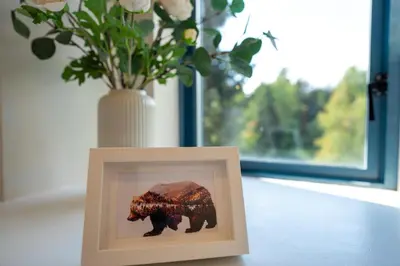 a picture of a bear in a picture frame next to a vase at Alpenglow Lodge Two Bedroom Apartment by MVA in Whistler