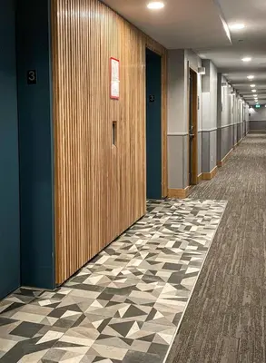 a hallway of an office building with a checkered floor at Alpenglow Lodge Junior One Bedroom by MVA in Whistler