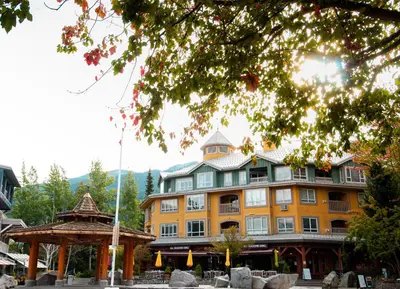 a large yellow building with a gazebo in front of it at Bear Lodge Two Bedroom by MVA in Whistler
