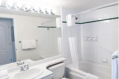a white bathroom with a tub and a sink and a toilet at Bear Lodge Two Bedroom by MVA in Whistler