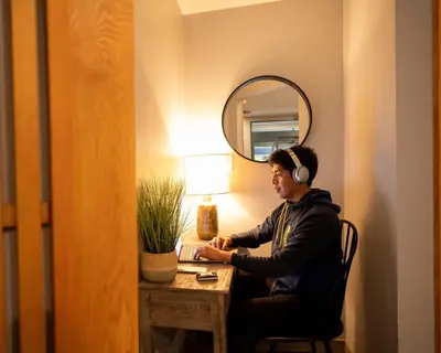 a man wearing headphones sitting at a desk in a room at Alpenglow Lodge Studio with park view by MVA in Whistler