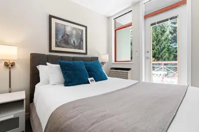 a bedroom with a large bed with blue pillows at Alpenglow Lodge Bear Wonder One Bedroom by MVA in Whistler