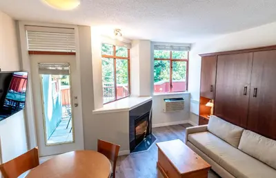 a living room with a couch and a table at Alpenglow Lodge Family Studio with Murphy Bed by MVA in Whistler