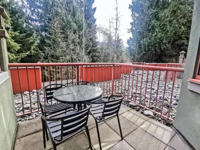 a patio with a table and chairs on a balcony at Alpenglow Lodge Family Studio with Murphy Bed by MVA in Whistler