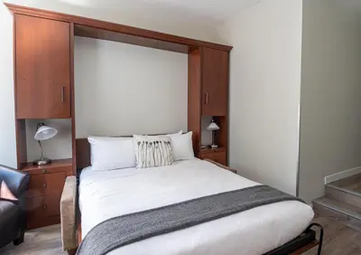 a bedroom with a large bed with a wooden headboard at Alpenglow Lodge Family Studio with Murphy Bed by MVA in Whistler