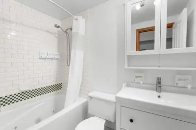 a white bathroom with a sink and a tub and a toilet at Alpenglow Lodge Family & Work Retreat by MVA in Whistler