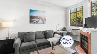 a living room with a couch and a tv at Alpenglow Lodge Large Studio with Dedicated Work Space by MVA in Whistler