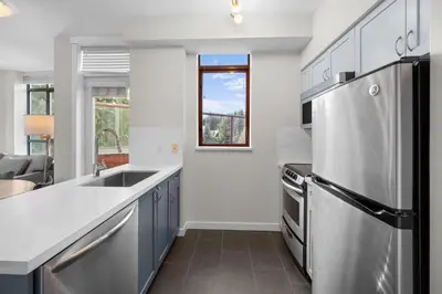 a kitchen with a sink and a refrigerator at Alpenglow Lodge Two Bedroom Apartment with Private Hot Tub by MVA in Whistler
